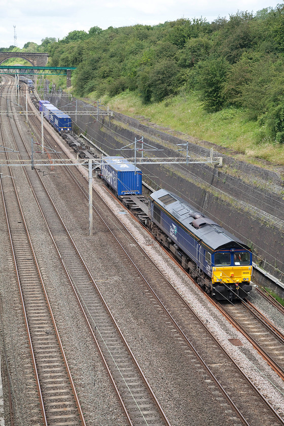 66424, 13.06 Daventry-Felixstowe North (4L57), Roade Cutting 
 66424 climbs through Roade Cutting with the 13.06 Daventry to Felixstowe Freightliner service. This is 4L57 usually goes to Tilbury but today, Felixstowe is it destination. It is not particularly heavily laden given the number of empty flats in evidence. 
 Keywords: 66424 13.06 Daventry-Felixstowe North 4L57 Roade Cutting