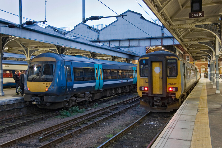 156407 LE 16.45 Norwich-Sheringham & 170270, LE 16.40 Norwich-Great Yarmouth, Norwich station 
 Having changed from British Summertime the previous weekend by 16.30 (when this photograph was taken) it is dusk. At Norwich station with the lights now on 170270 gets ready to work the 16.40 to Great Yarmouth with 156407 leaving five minutes later with the 16.45 to Sheringham. 
 Keywords: 156407 16.45 Norwich-Sheringham 170270 16.40 Norwich-Great Yarmouth, Norwich station