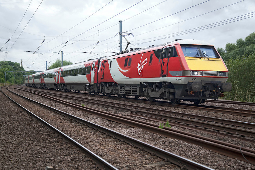 91012, GR 09.00 London Kings Cross-Edinburgh (1S09, RT), Gills Crossing 
 The 09.00 King's Cross to Edinburgh is some 55 miles into its 392 miles journey as it passes Offord Cluny just south of Huntingdon. It is lead by 91102 that looks smart in it VTEC livery, one that suits these train sets very well. 
 Keywords: 91012 1S09 Gills Crossing