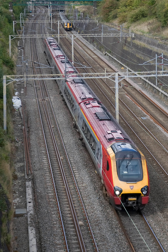 Class 221, VT 10.55 Holyhead-London Euston (1A27) & 350115 & 350103, LM 11.37 Crewe-London Euston (1U30), Roade cutting 
 The race is on but I suspect that I know which train will get to Euston first! To the left a Virgin Voyager races through Roade cutting working the 1A27 10.55 from Holyhead whilst to the right a twin set London Midland Desiro formed by 350115 and 350103 works the 11.37 from Crewe. 
 Keywords: Class 221 10.55 Holyhead-London Euston 1A27 350115 350103 11.37 Crewe-London Euston 1U30 Roade cutting Virgin Voyager London Midland Desiro