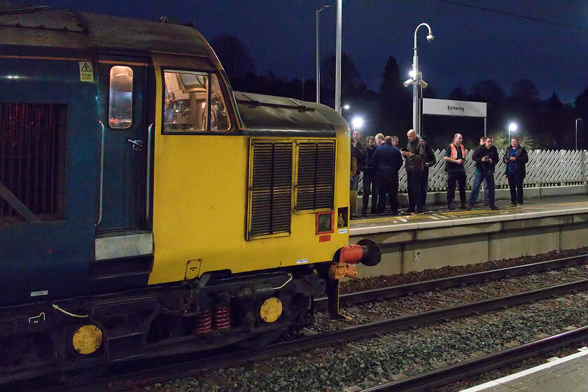 Enthusiasts, 37403, outward leg of 'The Wolf Hall Thunderer', 05.25 Derby-London St. Pancras (1Z40, 10L), Kettering station 
 Generous dwell times on railtours, when they are running to time, permits enthusiasts on board to alight and take their photographs of their train. Even in the dark at Kettering station, the hardy souls are seen doing this having alighted from their warm coaches! They are recording 37403 'Isle of Mull' as it waits at the head of The Wolf Hall Thunderer charter running as 1Z40, the 05.52 Derby to St. Pancras with 50008 'Thunderer' on the rear. On arrival in the capital, the train would take a circuitous route around south London with a number of reversals something that the track bashers aboard would really appreciate. 
 Keywords: Enthusiasts 37403 The Wolf Hall Thunderer 05.25 Derby-London St. Pancras 1Z40 Kettering station Isle of Mull Glendarroch Ben Cruachan