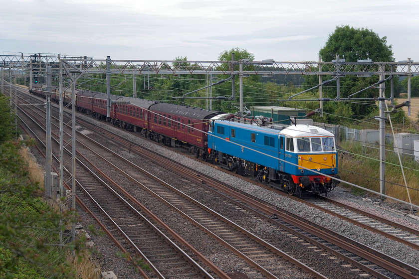 86259, outward leg of The Cumbrian Mountain Express, 07.10 London Euston-Calisle (1Z86), Hungate End SP784465 
 Bringing a dash of colour to the otherwise dull countryside, 86259 'Les Ross/Peter Pan' leads the 07.10 Euston to Carlisle Cumbrian Mountain Express. The train is drawing away from its stop at Milton Keynes a little unusually on the down fast. Control normally path it on the down slow as far as Hanslope Junction, that is about a mile north of here. After a couple of Virgin services pass on the fast the CME is permitted to cross and follow them on the fast. 
 Keywords: 86259 The Cumbrian Mountain Express 07.10 London Euston-Calisle 1Z86 Hungate End SP784465