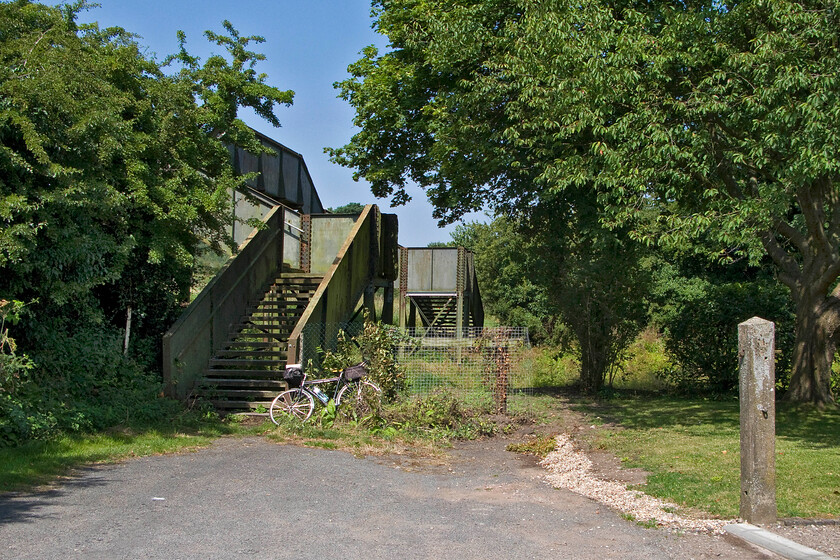 Former station footbridge & station entrance, Hammerwich SK074071 
 The former station footbridge at Hammerwich is seen in the summer sunshine. The entrance to the station (closed 18.01.65) is marked by the concrete gatepost to the right of the image. My bike leans against the fence at the base of the steps of the bridge that were not in the best of condition despite it still being in use as a footpath crossing over the closed South Staffordshire Railway trackbed. 
 Keywords: Former station footbridge station entrance Hammerwich SK074071 North Staffordshire LIne