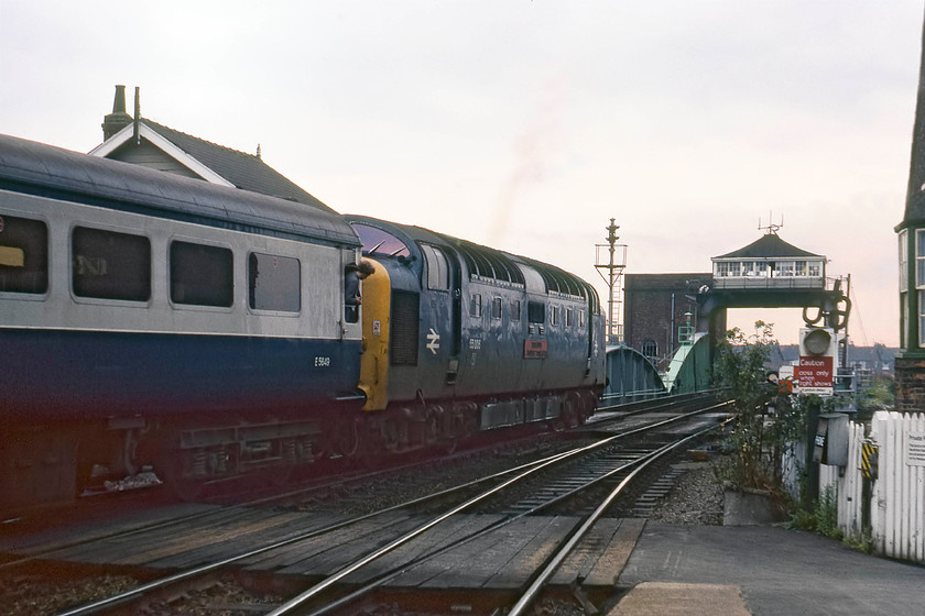 55006, 14.05 London King`s Cross-York (1L43), Selby station 
 A scene that is full of historical interest to the north of Selby station. 55006 'The Fife and Forfar Yeomanry' takes the 14.05 King's Cross to York away from the station and is about to cross the swing bridge. The signal box that controls the operation of the swing bridge straddles the up and down running lines with the accumulator tower to the left just behind it. The roof and gable end of the closed Selby signal box is behind the train. Notice the enthusiast hanging out of the droplight taking in the grandeur of a Deltic doing what it did best, namely, making a lot of noise as it accelerates rapidly with a fast express train! But, having said that, the train is severely speed restricted until the last carriage has passed over the swing bridge, but then it will all kick off! 
 Keywords: 55006 14.05 London King`s Cross-York 1L43 Selby station