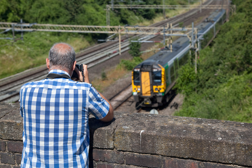 Andy photographing class 350, LN 10.14 Birmingham new Street-London Euston (1Y28, RT), Victoria Bridge 
 My spotting companion, Andy, captures a class 350 working the 10.14 Birmingham New Street to London Euston on his Canon D60. He is leaning on the parapet of Victoria Bridge between Northampton and Milton keynes, one of my favourite spots that is just near my home. 
 Keywords: 1Y28 Victoria Bridge