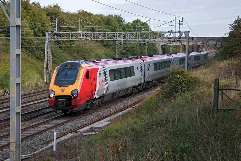 Class 221, VT 16.10 London Euston-Bangor, Roade 
 Virgin's evening 16.10 Euston to Bangor service approaches Roade worked by an unidentified Voyager. I ought to have been able to get the number as the train passed but with my aging eyes this has become more difficult than it used to be; what about the rest of you out there? 
 Keywords: Class 221 16.10 London Euston-Bangor Roade Virgin West Coast Voyager