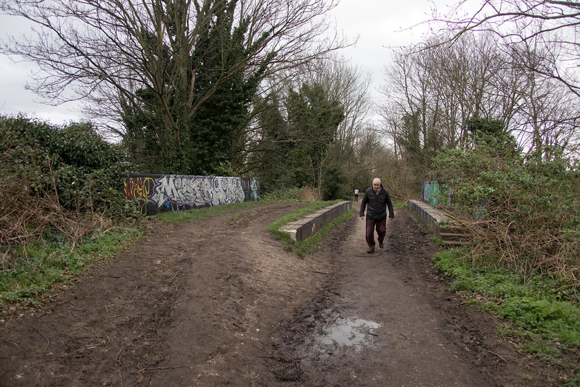 Andy, Parkland Walk, crossing Mount Pleasant Villas 
 Andy spent the first ten years of his life in Finsbury Park living very close to where this photograph was taken crossing Mount Pleasant Villas road on the Parkland Walk. He reported that as a young railway enthusiast in the late 1960s he remembered seeing north London suburban stock shunted in and out of the remaining track close to this location. The stock accessed the sidings by the mainlines and next to the park via a flyover that crossed the ECML just north of Finsbury Park station. Coaches were stabled there during the day in between use on commuter services in and out of the capital. 
 Keywords: Andy Parkland Walk crossing Mount Pleasant Villas