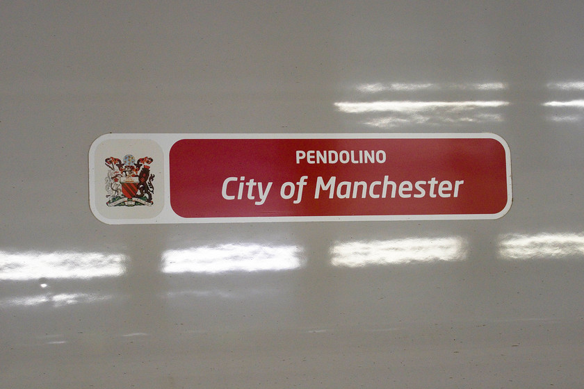 Nameplate (vinyl), 390014, VT 19.30 London Euston-Glasgow Central (1S06, 66L), London Euston-station 
 When the Pendolinos have been having their mid-life refurbishments the original cast nameplates have been removed and replaced by these offerings! Vinyl 'nameplates' are not really in the best traditions of our enviable railway heritage but I suppose cost and expediency rule the day! 390014 'City of Preston' is about to leave Euston with the 19.30 to Glasgow Central. Unfortunately, something went very wrong in the Crewe area with this service arriving over an hour late into Glasgow with passengers grabbing their delay-repay claim forms as they trudged wearily down platform one no doubt! 
 Keywords: Nameplate vinyl 390014 19.30 London Euston-Glasgow Central 1S06 London Euston-station