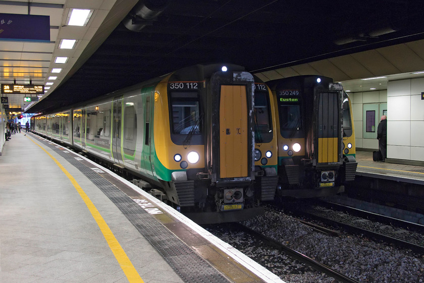 350112, LN 13.22 Wolverhampton-Walsall (2A29, RT) & 350249, LN 12.05 Liverpool Lime Street-London Euston, ran as 12.16 ex Liverpool South Parkway (9Y12, 8L), Birmingham New Street station 
 Inside the darkness of the 'new' New Street station two London Northwestern Desiros stand side by side at platforms one and two. To the left, 350112 will soon depart with the 13.22 Wolverhampton to Walsall local. Meanwhile, 350249 is just getting underway forming the 12.05 Liverpool Lime Street to Euston that today ran as the 12.16 from Liverpool South Parkway. All trains in and out of Liverpool Lime Street were delayed due to problems with signalling leading to services terminating early and starting from other stations. 
 Keywords: 350112 13.22 Wolverhampton-Walsall 2A29 350249 12.05 Liverpool Lime Street-London Euston 12.16 ex Liverpool South Parkway 9Y12 Birmingham New Street station Desiro London North Western Railway