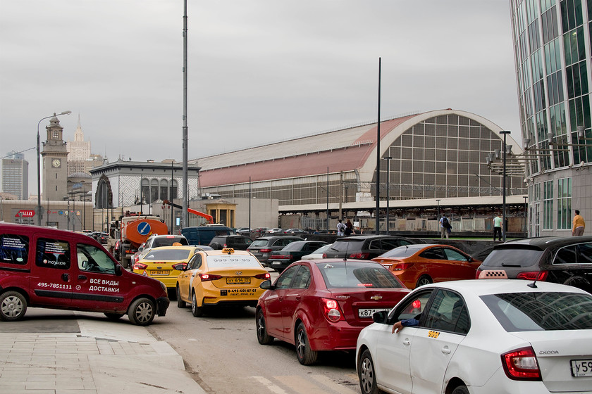 Train shed, Moscow Kiyevsky station 
 Home time in Moscow is characterised by unbelievable congestion! We walked along the side of this line of cars for some ten minutes and they simply did not move. In the background is Moscow's Kiyevsky station with its huge train shed. Trains from Kiyevsky generally go south and west from the city principally to Ukraine and some of the Baltic states. There used to be true inter-continental services to Romania, Hungary and as far as Venice. There are also a number of suburban platforms and the airport express services to Moscow's Vnukovo airport. 
 Keywords: Train shed, Moscow Kiyevsky station