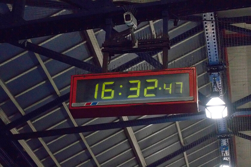 NSE click-clack clock, London Victoria station 
 I took this photograph quickly and discreetly before lowering my hat and moving off into the melee of Victoria station! The reason, of course, was that I was committing some sort of offence not because I was photographing a fabled click-clack clock but due to the CCTV camera installed above it. Victoria remains a bastion of these Network South East installed clocks with a number of them scattered around the station but this one is interesting as it has its NSE flash running along the bottom. This particular example is located under the canopy right at the front of Victoria, raise your head next time you are entering the station! 
 Keywords: NSE click-clack clock London Victoria station