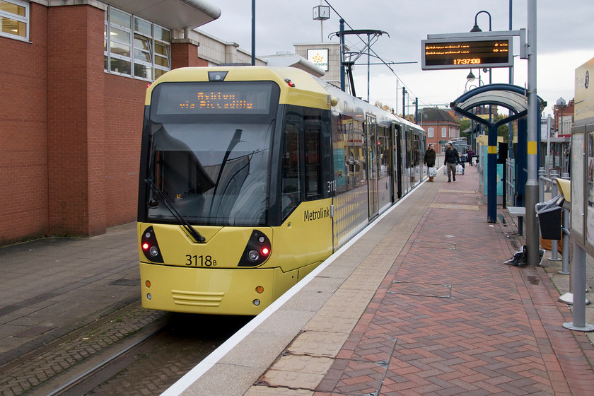 3118, Eccles-Ashton-under-Lyne working, Eccles station 
 Metrolink's 3118 waits to leave Eccles tram stop with a service to Ashton-under-Lyne. I took this tram as far as Piccadilly station. The large building to the left is a Morrisons supermarket that occupies the site of the former Eccles bus station. 
 Keywords: 3118 Eccles-Ashton-under-Lyne working Eccles station