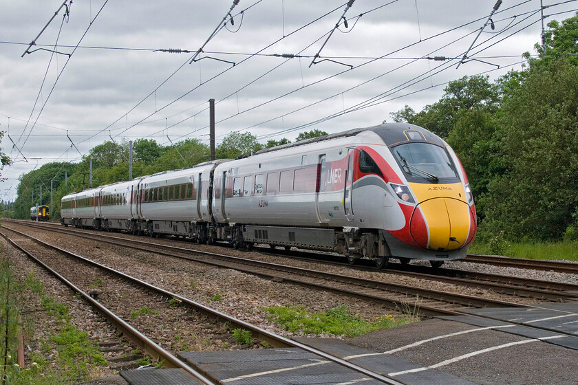 800203, GR 09.36 Harrogate-London King's Cross (1A22, 1L) & 158785, EM 10.40 Nottingham-Norwich (1L07, 2E), Lolham level crossing 
 The speed differential between the Azuma and the Express Sprinter was clear to see here at Lolham level crossing located between Tallington and Helpston. 800203 working the 09.36 Harrogate to King's Cross has just shot past 158785 forming the 10.40 Nottingham to Norwich service. 
 Keywords: 800203 09.36 Harrogate-London King's Cross 1A22 158785 10.40 Nottingham-Norwich 1L07 Lolham level crossing LNER Azuma EMR