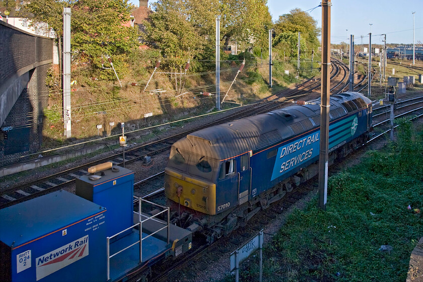 57010, unidentified up RHTT, Thorpe Junction 
 An image that has needed a fair bit of Photoshop treatment! I hate extreme lighting in my photographs, particularly burnt out light areas at the expense of darker ones. With digital photography, it is easier to lighten up under-exposed areas with them often containing a surprising amount of detail in the blackness! So, I tend to expose an image for the sky and other brightly lit areas and then split that area away as a layer enabling me to then deal with the darker area sepparatly. It has worked reasonably well here at Thorpe Junction near Norwich station. It shows 57010 leaving with an unidentified RHTT train that I presume was returning to its base at Stowmarket. 
 Keywords: 57010 RHTT Thorpe Junction DRS Direct Rail Services