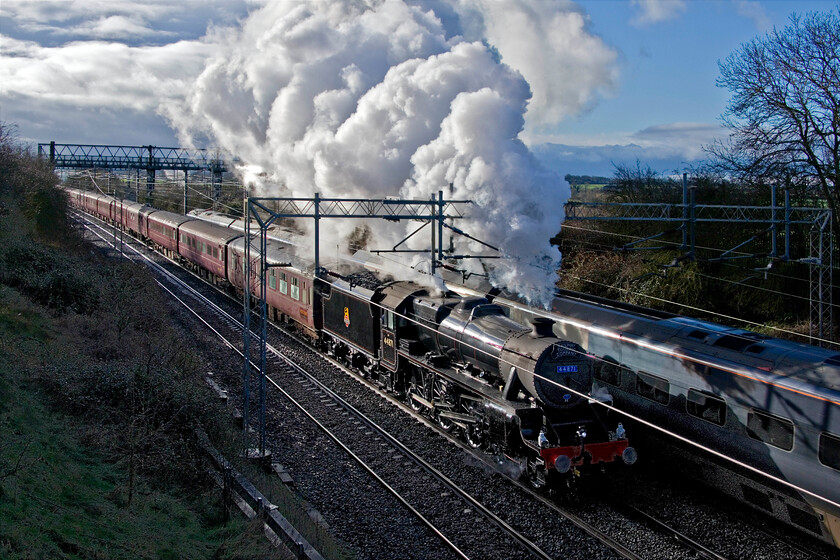 44871, outward leg of The Chesireman, 07.13 London Euston-Chester (1Z72, 6L), Castlethorpe SP790453 
 What a difference a quarter of an hour makes! From the time of taking the previous photograph, the light has been transformed with some blue sky allowing the sun to break through. Unfortunately, it is somewhat side-on for this location producing the ultimate in 'glint shots'! Producing a dramatic exhaust Black 5 44871 accelerates away from a signal check near Wolverton leading The Chesireman charter running as 1Z72. Steam charters on the very busy southern WCML are not particularly common so I always make the effort to get out and capture it. Notice the Pendolino speeding south passing the scene. 
 Keywords: 44871 The Chesireman 07.13 London Euston-Chester 1Z72 Castlethorpe SP790453