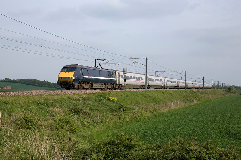 91118, GR 17.21 Peterborough-Leeds (1D22), Frinkley Lane crossing SK906436 
 My last photograph of the day at Frinkley Lane crossing and an interesting one! The 17.21 Peterborough to Leeds service is being led by 91118 that still wears its former GNER livery. Over seven years after GNER had ceased to operate on the ECML National Express East Coast did not get around to repainting it and now the state-owned (or directly operated as the government prefer to call it!) East Coast has also done nothing apart from to apply its branding along the white stripe. 
 Keywords: 91118 17.21 Peterborough-Leeds 1D22 Frinkley Lane crossing SK906436 GNER East Coast