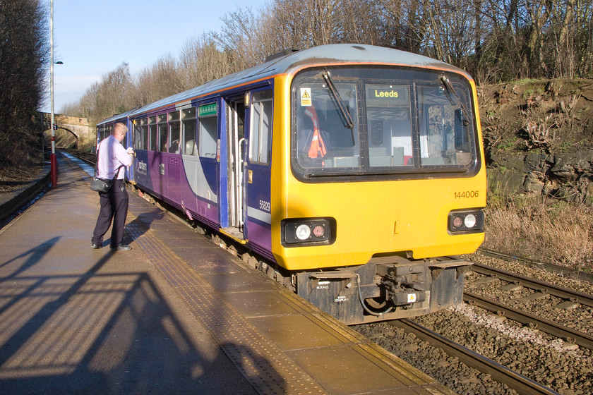 144006, NT 09.06 Sheffield-Leeds (2L18), Woodlesford station 
 The guard of the 09.06 Sheffield to Leeds service looks a little under-dressed for this chilly February morning. The train has paused at Woodlesford station south east of Leeds that has a split platform with the other one just behind me. We have just alighted from the train having travelled from Sheffield. 
 Keywords: 144006 09.06 Sheffield-Leeds 2L18 Woodlesford station