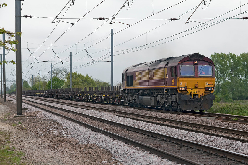 66186, 09.11 Dollands Moor-Scunthorpe Redbourn (4E28), White House Crossing TL227777 
 EWS liveried 66186 works the 09.11 Dollands Moor to Scunthorpe on the down slow past White House Crossing just north of Huntingdon on the ECML. This is train of flats designed to carry lengths of rail. 
 Keywords: 66186 09.11 Dollands Moor-Scunthorpe Redbourn 4E28 White House Crossing TL227777