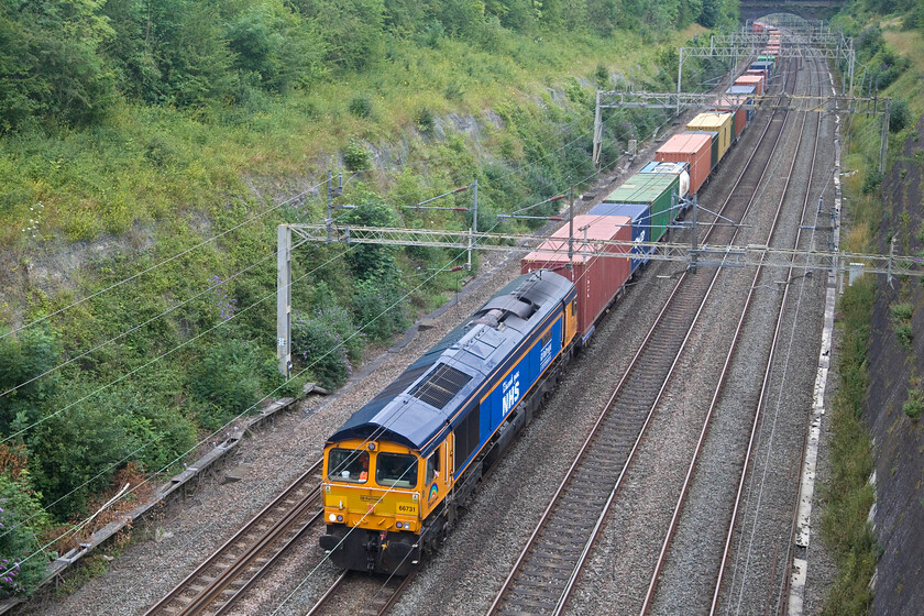 66731, 12.29 Felixstowe North-Trafford Park (4M21, 3L), Roade cutting 
 A second named Class 66 passes north through Roade cutting within a few minutes of the first. This time, it's one of GBRf's finest in the form of 66731 Captain Tom Moore-A true British inspiration' leading the 4M21 12.29 Felixstowe to Trafford Park service. 66731 is still adorned with its Thank You NHS vinyls a legacy, as is its name, of the COVID crisis of 2020. 
 Keywords: 66731 12.29 Felixstowe North-Trafford Park 4M21 Roade cutting Captain Tom Moore-A true British inspiration'