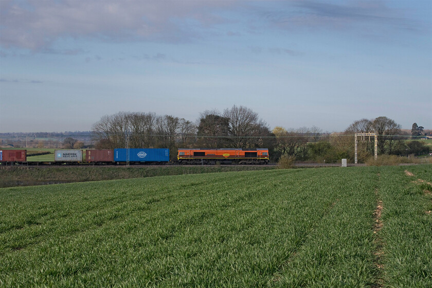 66415, 03.00 Felixstowe North-East Midlands Gateway (44E), between Roade & Ashton 
 On the walk home across the fields, the final freight of this hour out was seen heading north. 66415 'You Are Never Alone' in its Freightliner-Genesee & Wyoming livery as applied to a number of the Class 66s. Once again, the sun has not played ball with the fields in the background bathed in the morning light but the foreground and the train in semi-shade! 
 Keywords: 66415 03.00 Felixstowe North-East Midlands Gateway between Roade & Ashton You Are Never Alone