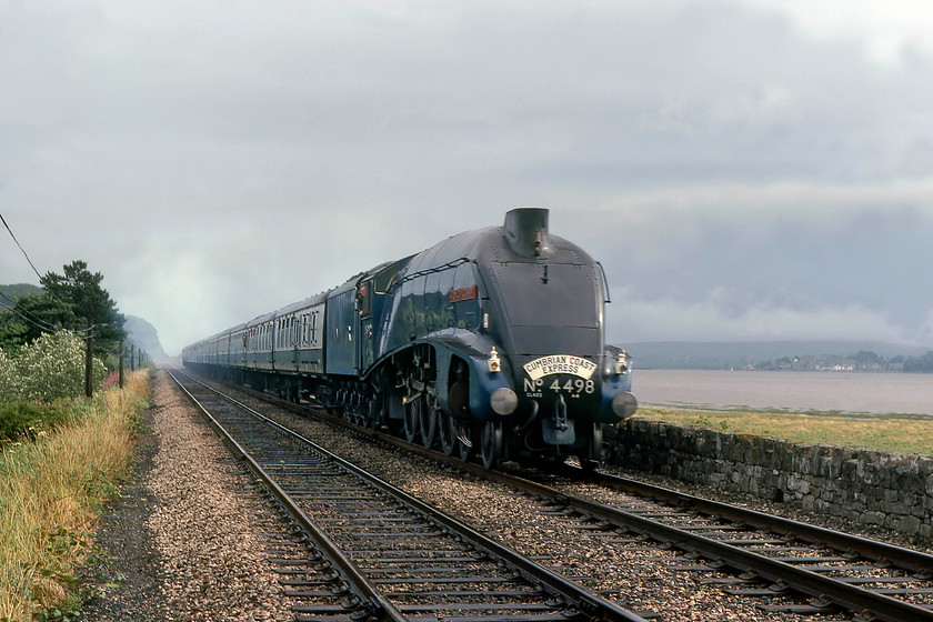 4498, outward leg of The Cumbrian Coast Express, 10.23 Blackpool North-Sellafield, Grange-Over-Sands SO422785 
 Running along the side of the estuary of the River Kent with the village of Arnside in the background, 4498 'Sir Nigel Gresley' leads the outward leg of The Cumbrian Coast Express on the approach to Grange-Over-Sands. The railtour left Blackpool North at 10.23, led by 40143 with 4498 taking the helm at Carnforth, running as far as Sellafield. Unfortunately, due to the grey sky and that the train was slowing for its thirty minute stop at Grange-Over-Sands, there is no exhaust. Despite appearances, I am not trespassing but standing on a level crossing where a track crosses the line leading to the delightful Holme Island. 
 Keywords: 4498 The Cumbrian Coast Express 10.23 Blackpool North-Sellafield Grange-Over-Sands SD422785