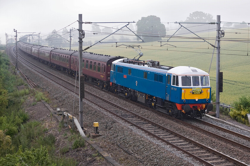 86259, outward leg of The Cumbrian Mountain Express, 07.09 London Euston-Carlisle (1Z86), Blisworth SP735539 
 Unfortunately, despite the fog lifting it was not happening quickly enough for the sun to illuminate 86259 'Les Ross/Peter Pan' as it works the outward leg of The Cumbrian Mountain Express that left Euston at 07.09 heading, ultimately, for Carlisle. The AC electric would come off the train at Carnforth where 60009 'Union of South Africa' would take over leading the train later southwards over the fabled and Settle and Carlisle route. The train is seen passing near to the village of Blisworth on the Weedon route in Northamptonshire. 
 Keywords: 86259 The Cumbrian Mountain Express, 07.09 London Euston-Carlisle 1Z86 Blisworth SP735539 Les Ross Peter Pan