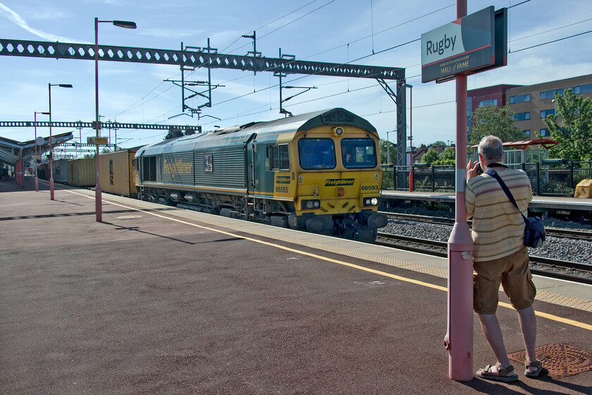 66593, 03.00 Felixstowe North-East Midlands Gateway (4M86, 55E), Rugby station 
 On a very warm early summer morning Andy attempts to take a reasonable photograph of the 4M86 03.00 Felixstowe to East Midlands Gateway in the very tricky lighting. 66593 '3MG Mersey Multimodal Gateway' leads the Freightliner service away from Rugby after a lengthy crew change of some five minutes. 
 Keywords: 66593 03.00 Felixstowe North-East Midlands Gateway 4M86 Rugby station Freightliner 3MG Mersey Multimodal Gateway