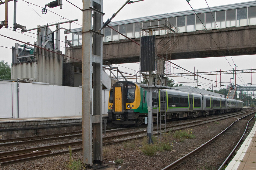 350118, LM 13.13 London Euston-Birmingham New Street, Northampton station 
 Under the partially dismantled former station footbridge at Northampton, 350118 waits to depart with the 13.13 service to Birmingham New Street. The challenges of keeping a station fully operational during a full re-build must be a H&S officer's nightmare! However, being such a busy station Northampton needs to be kept open all especially the thousands of commuters who use the station every day. 
 Keywords: 350118 13.13 London Euston-Birmingham New Street Northampton station London Midland Desiro