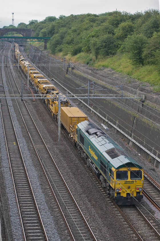 66547, Willesden-Birmingham International HOBC (6Y15), Roade cutting 
 The rear of the 6Y15 Willesden to Birmingham International High Output Ballast Cleaner (HOBC) train trails through Roade cutting with 66547 giving it a shove from the rear. This heavy and long train travels around the country to various work sites in order to collect, clean and then deposit the ballast ready for tamping. 
 Keywords: 66547 Willesden-Birmingham International HOBC 6Y15 Roade cutting High Output Ballast Cleaner HOBC