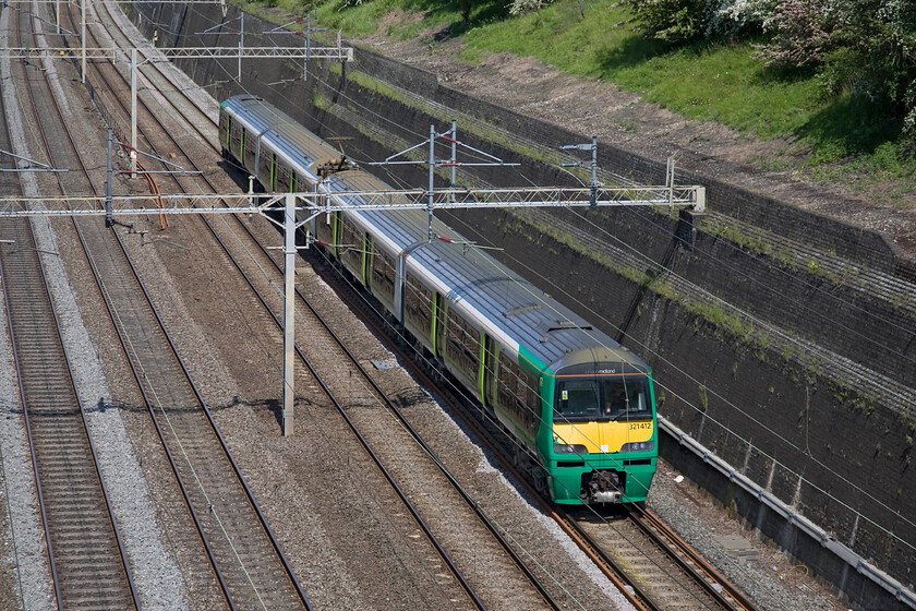 321412, LM 11.45 Northampton EMD-Watford Junction ECS (5F17), Roade cutting 
 London Midland retains a small number of Class 321s to cover commuter services during the morning and evening peaks between Northampton and Euston. They have been repainted into a version of their livery using the recognisable house colours. 321412 passes through Roade cutting working the 5F17 11.45 Northampton to Watford Junction empty coaching stock move. 
 Keywords: 321412 11.45 Northampton EMD-Watford Junction ECS 5F17 Roade cutting London Midland