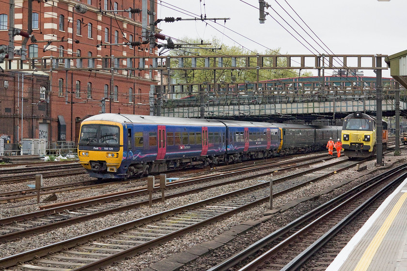 165129 & 165105, GW 13.07 Oxford-London Paddington (2P54, 5L) & 70807, stabled, Royal Oak LU station 
 The 4-car 13.07 Oxford to Paddington composed of 165129 and 165105 passes Royal Oak LU station as it enters the throat of Paddington station. It is passing Colas 70807 and some track-workers. The 70 was stabled on a possession line as there was extensive Easter bank holiday weekend work taking pace and the north eastern side of the station. 
 Keywords: 165129 165105 2P54 70807 Royal Oak LU station