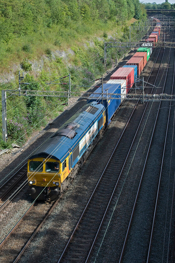 66709, 12.29 Felixstowe North-Trafford Park (4M21, 18E), Roade cutting 
 Wearing its one-off livery 66709 'Sorrento' leads the 4M21 12.29 Felixstowe to Trafford Park Freightliner service through Raode cutting. Not that I want to promote such a poor-quality image, but I last photographed this locomotive on a very different sort of day, also passing Roade, back at the start of the year in January, see....https://www.ontheupfast.com/p/21936chg/30050050931/x66709-10-36-felixstowe-north-trafford 
 Keywords: 66709 12.29 Felixstowe North-Trafford Park 4M21 Roade cutting Sorrento