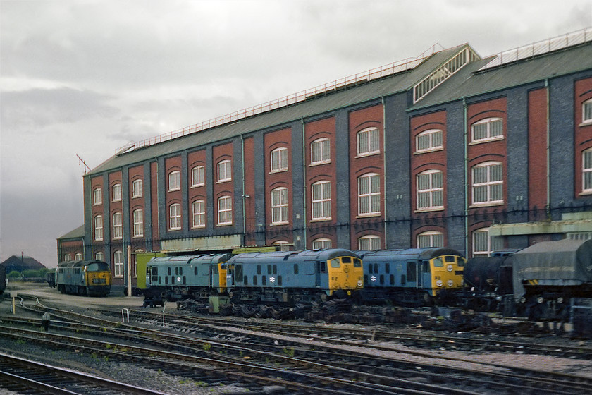 24079, 24134, D1041, awaiting cutting, Swindon Works 
 Tree class 24s, the two front ones being identified as 24079 and 24134 await their fate with D1041 'Western Prince' outside Swindon Works. To the far right of the image, under the tarpaulin, I think lurks a crane, possibly one of Swindon's steam cranes? The A shop standing behind was the former boiler and wheel shop has now been demolished and is the site of many modern houses that line the appropriately named Penzance Drive. 
 Keywords: 24079 24134 D1041 awaiting cutting Swindon Works