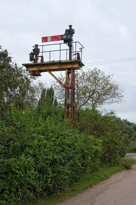 Home bracket signal, Twenty Feet River crossing 
 A seemingly insignificant bracket signal at Twenty Feet River just to the north of March on the former GN & GE Joint line. It once had two home signals that permitted trains to pass southwards over the road just visible on a level crossing. The arm still in place was for the up main that trains would follow straight through and into March whilst the doll with the missing arm would have controlled access into the massive Whitemoor Yard once the largest marshalling Yard in Europe. The signal is withing the boundary of the former level crossing keeper's house to the left now a private residence. 
 Keywords: Home bracket signal Twenty Feet River crossing