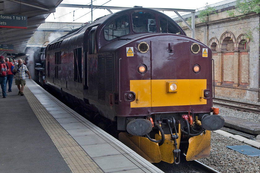 37706 & 44781, taking water, Crewe station 
 After the visit to DRS at Gresty Bridge, Andy and I returned to Crewe station in time to see the various activity underway there. Unfortunately, with the intense dry weather that was so much of a feature of the summer 2018, steam was banned on the network unless piloted by a diesel. This lead to scenes such as this at Crewe with 44781 tucked in behind 37706. The combo had run down from Carnforth to Crewe and after this water stop headed on to Bristol via the Welsh Marches route. 
 Keywords: 37706 44781 Crewe station