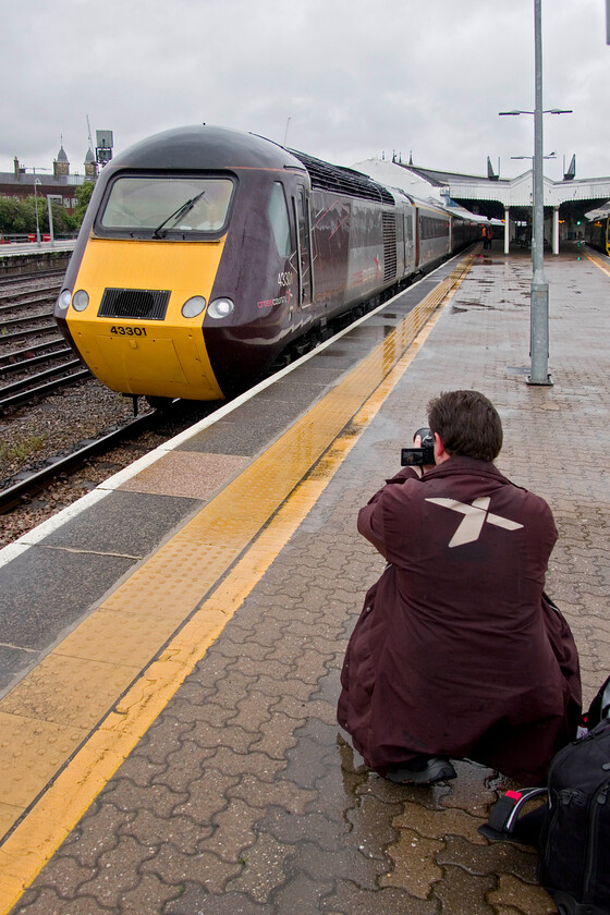 43301, XC 06.12 Leeds-Plymouth (1V44, 4L), Bristol Temple Meads station 
 Even the staff are getting in on the act recognising the historical nature of the next six weeks or so prior to the demise of the HST operating as a full-length train that is on inter-regional services. This had been our guard on the 1V44 06.12 Leeds to Plymouth who crouches down in the pouring rain to take his own photograph of this iconic piece of British engineering! He was probably not born back in 1976 when they entered service between here at Bristol and Paddington (as well as South Wales of course) but such is their enduring appeal some forty-seven years later! I suspect that there will be many other people photographing the two CrossCountry diagrams over the coming few weeks prior to their demise. 
 Keywords: 43301 06.12 Leeds-Plymouth 1V44 Bristol Temple Meads station CrossContry HST