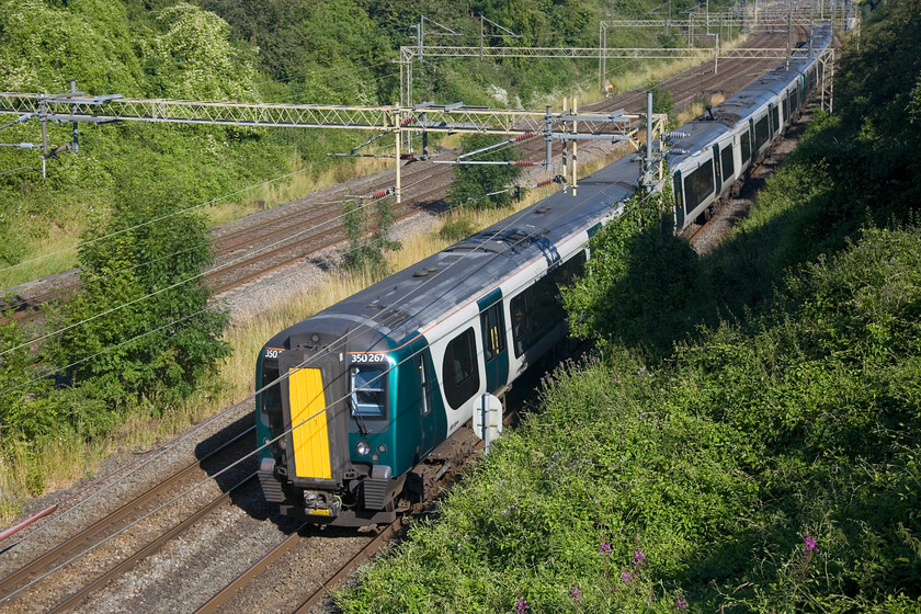 350267, LN 08.50 Northampton-London Euston (2N00, 27L), Victoria bridge 
 Having just seen the first down Avanti service of the day head north the first up London Northwestern train passes Victoria bridge near Roade on this bright Sunday morning. 350267 leads two other sets as the 08.50 Northampton to Euston train. 
 Keywords: 350267 08.50 Northampton-London Euston 2N00 Victoria bridge London Northwestern Desiro