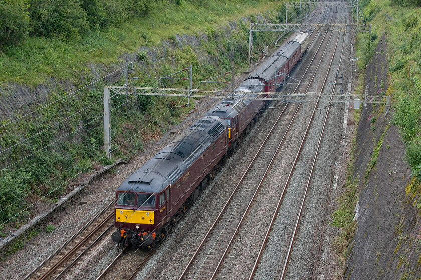 47746 & 57010, 10.10 Southall WCR-Carnforth Steamtown (5M43, 130E), Roade cutting 
 I was not at all sure what to expect from the 10.0 Southall WCR to Carnforth empty stock move or even if it would run when I spotted it on RTT in the morning. In addition, there were no postings on any of the forums logging its progress so I was intrigued to see what would appear around the curve at the end of Roade cutting. 47746 and 57010 lead just three of WCR's coaches that were being taken back to their Lancashire base running as 5M43 which seemed a slightly odd reporting number for such a service with 4 signifying a fast freight (seventy-five mph) and M that it originated in the Midlands. 
 Keywords: 47746 57010 10.10 Southall WCR-Carnforth Steamtown 5M43 Roade cutting West Coast Railways