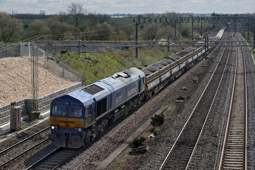 66727, 10.18 Kings Langley-Bescot (6G52, 3E), Ashton Road bridge 
 66727 'Maritime One' leads the third infrastructure working of the morning and is seen about to pass under Ashton Road bridge just south of Roade. The train is composed of a rake of loaded MRA wagons and a number of flats towards the rear. Just visible at the rear is DRS liveried 66304. 
 Keywords: 66727 10.18 Kings Langley-Bescot 6G52 Ashton Road bridge Maritime One