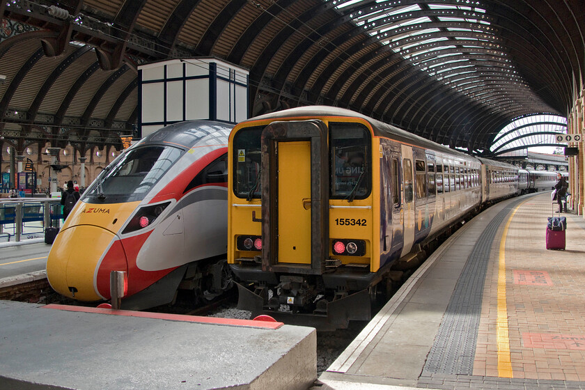 801216, GR 12.02 York-Peterborough (1Y84, 4E) & 155342, NT 11.45 York-Hull (2R13, 1E), York station 
 801216 sits stabled at York next to 155342. In terms of railway technology the two trains are decades apart and they are both doing their jobs serving the travelling public but time has not meant universal improvements. I would sooner have the seating on the elderly Class 155 than that of the new Electric! The LNER train will work the 12.02 to Peterborough whilst the Northern unit will soon leave with the 11.45 to Hull. 
 Keywords: 801216 12.02 York-Peterborough 1Y84 155342 11.45 York-Hull 2R13 York station LNER Azuma Northern Trains