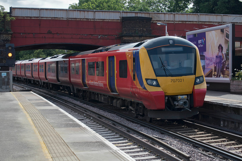 707021, SW 09.58 London Waterloo-Windsor & Eton Riverside (2U23, RT), Richmond station 
 In its new bright red livery, 707021 arrives at Richmond station in the morning summer sun (but taken the wrong side of it!) working the 09.58 Waterloo to Windsor and Eton Riverside service. I have not yet managed to travel on one of these relatively new class 707s to compare with their AC 700 cousins. 
 Keywords: 707021 09.58 London Waterloo-Windsor & Eton Riverside 2U23 Richmond station