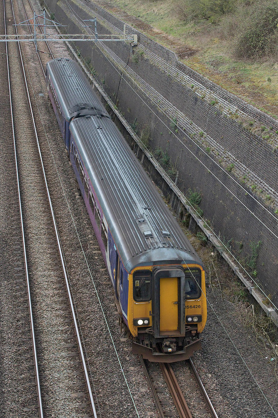 156426, NT 13.16 Newton Heath TMD-Wolverton Centre Sidings (5J70, 38E), Roade cutting 
 Having now outlived most of the first generation DMUs that they replaced, the Class 156 Super Sprinters are now over thirty years old. Despite this, they live on and are still receiving work to prepare them for future use. More likely to be seen at Newcastle, Buxton or Southport, Northern's 156426 is well away from its usual haunts as it passes through Roade cutting with the 13.16 Newton Heath to Wolverton Works 5J70. On arrival at the centre sidings, it will be permitted access to the works via the tunnel under the fast lines. Over the coming few weeks it will receive Northern's new livery and be in receipt of an interior 'refresh' along with other modifications and improvements. 
 Keywords: 156426 13.16 Newton Heath TMD-Wolverton Centre Sidings 5J70 Roade cutting Northern Super Sprinter