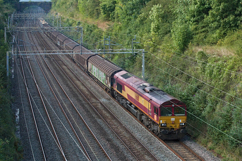 66111, 11.32 Ditton Foundry-Dollands Moor (6026, 3E), Hyde Road bridge 
 Leaving a smokey trail through Roade cutting former EWS operated (still wearing its colour scheme) 66111 leads the 6O26 11.32 Ditton Foundry to Dollands Moor for later onward movement through the tunnel to the continent. Usually a short train, as per today, it conveys parts and supplies from the JLR facility at Ditton supporting their dealers throughout Europe. 
 Keywords: 66111 11.32 Ditton Foundry-Dollands Moor 6026 Hyde Road bridge DB EWS