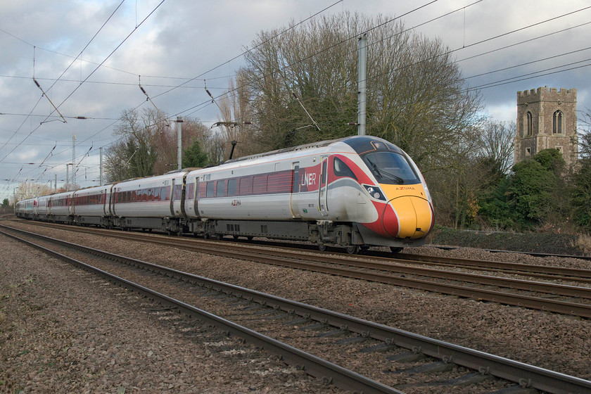 801110 & 801106, GR 11.45 Leeds-London King`s Cross (1A28, 4L), Gill`s Crossing 
 With Offord Cluny's All Saints church tower to the right of the image, two Azumas pass the village with the 11.45 Leeds to London King's Cross. 801110 and 801106 still look smart in their LNER livery but running two five-car sets coupled up cannot be the most effective way to operate a train service, I suspect that sometime in the future those who procured and ordered these trains may rue the day that the decision to order 'short sets' was made? 
 Keywords: 801110 801106 11.45 Leeds-London King`s Cross 1A28 Gill`s Crossing Azuma LNER The Church of All Saints Offord Cluny