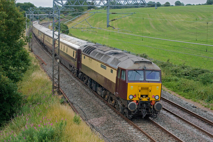 57313, 09.02 London Euston-Milton Keynes central (via Rugby) (1Z28, 4L), Milton crossing 
 57313 'Scarborough Castle' brings up the rear of the 1Z28 Euston to Milton Keynes via a reversal at Rugby Northern Belle charter as it passes Milton crossing between Roade and Blisworth. Passengers who would be going to the British Grand Prix and Silverstone would just be finishing their breakfasts ready to transfer to coaches on arrival at Milton Keynes. 
 Keywords: 57313 09.02 London Euston-Milton Keynes central Rugby 1Z28 Milton crossing Scarborough Castle Northern Belle