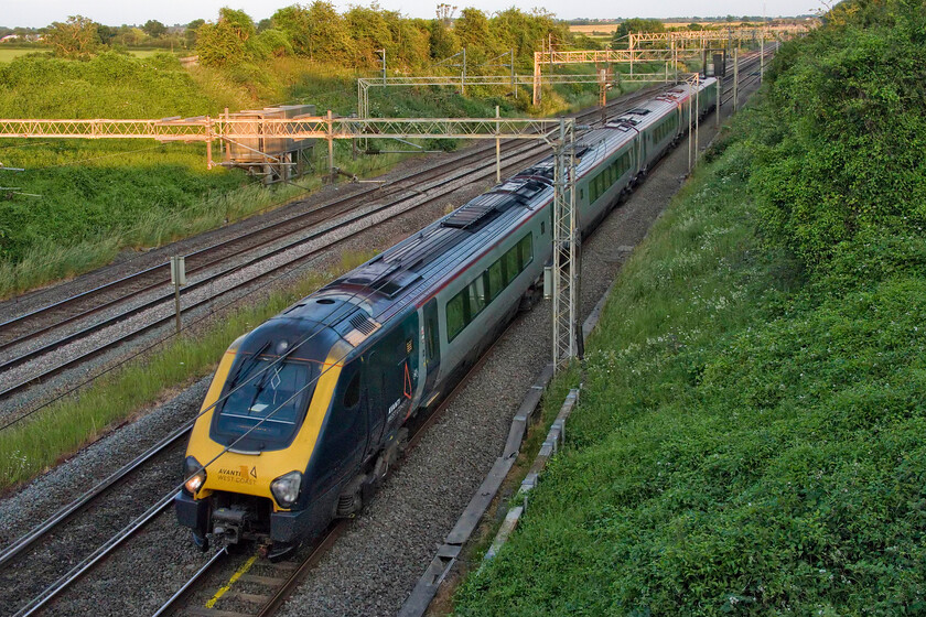 221111, VT 19.16 London Euston-Birmingham New Street (5G41, 31L), Victoria bridge 
 Running over half an hour late AWC's 221111 passes Victoria bridge working the 19.16 Euston to Birmingham New Street. The sun has set so low in the sky now on this, the day after the longest day, that only the fields in the background are in the sun on this pleasantly warm summer's evening. 
 Keywords: 221111 19.16 London Euston-Birmingham New Street 5G41 Victoria bridge AWC Avanti West Coast Voyager