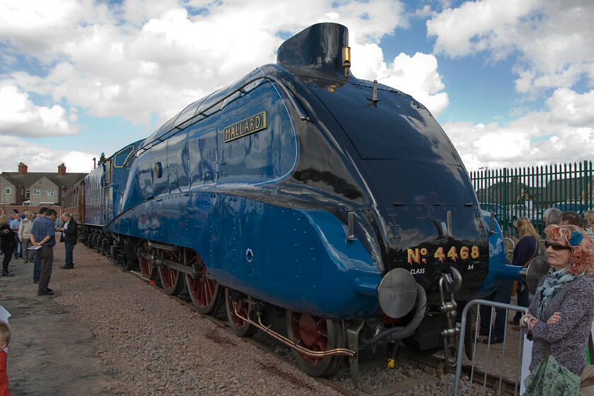 4468, on display, Mallard 75 celebrations, Grantham Yard 
 I had to wait for some time in order to get a front three-quarters view of record-breaking A4 4468 'Mallard' due to the crowds at Grantham. Eeven then the lady to the right is still in shot despite me standing there with my camera patiently waiting! Also, the sun had just gone behind some clouds but I had little choice! The fine-looking locomotive was on disply as part of the Mallard 75 celebrations. 
 Keywords: 4468 Mallard 75 celebrations Grantham Yard Mallard