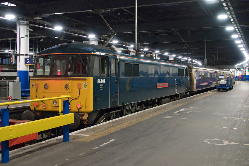 86101, CS 18.33 Wembley-London Euston sleeper ECS (5S95), London Euston station 
 86101 'Sir William Stanier FRS' has brought the Highland sleeper stock into Euston and sits at platform one. This ECS move was very late as was the departure, with it heading north from Euston only half an hour before the Lowland sleeper. Caledonian Sleeper now keeps passengers back (behind where I am standing) before boarding. On this evening, in the dingey heat of Euston, they were kept waiting for well over an hour, a very poor start a prestigious train journey. With the withdrawal of the Mk. III sleeper stock with the move over to the CAF Mk. Vs the use of the veteran electric will no longer be needed. 
 Keywords: 86101 CS 18.33 Wembley-London Euston sleeper ECS 5S95 London Euston station