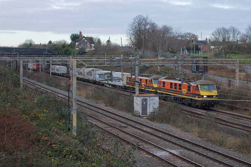 90012 & 90014, 10.20 Trafford Park-Felixstowe North (4L67, RT), site of Roade station 
 A pair of matching Freightliner Class 90s in their smart Genesee & Wyoming liveries pass Roade leading the 4L67 10.20 Trafford Park to Felixstowe service. Apologies for the poor placing of the double-headed locomotives but the pace at which electric-hauled services get their trains from Northampton to here still catches me out! 
 Keywords: 90012 90014 10.20 Trafford Park-Felixstowe North 4L67 site of Roade station Freightliner