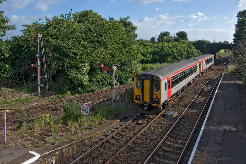 153914 & 153329, NT 08.10 Chester-Liverpool Lime Street (1B04, 1L), Helsby station 
 Having travelled the relatively short distance from Chester to Helsby on 153914 and 153329 I managed to take this wide-angled photograph of the train as it departed taken from the station footbridge. The semaphore signals bring a welcome sense of nostalgic warmth with them becoming increasingly rare on the network in 2022. Also of note in this image is the co-acting signal (HY38) which controls exit on to the mainline from the 'Cinderella' Ellesmere Port to Helsby line. Whilst the scene appears quiet and rural in nature looks can be deceiving. The M56 motorway is just a few hundred yards behind the trees to the left running parallel with the railway with its associated noise providing a constant soundtrack accompaniment! 
 Keywords: 153914 153329, NT 08.10 Chester-Liverpool Lime Street 1B04 Helsby station TfW Transport for Wales